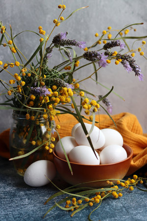 Simple composition still life with eggs. Easter card design. Still life with wild spring flowers in...