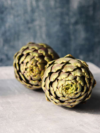Close up photo of two artichokes on textured background with copy space. Beautiful artichoke flowers texture. Balanced diet concept.の写真素材