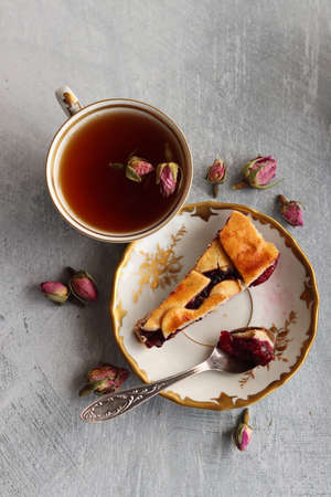 Simple composition still life with milk jug, cup of tea and an open book on a table. Close up photo of retro styled objects. Sunny day photo.の写真素材