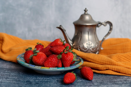 Still life with retro styled objects and juicy strawberry. Close up photo of organic fruit on a plate.の写真素材