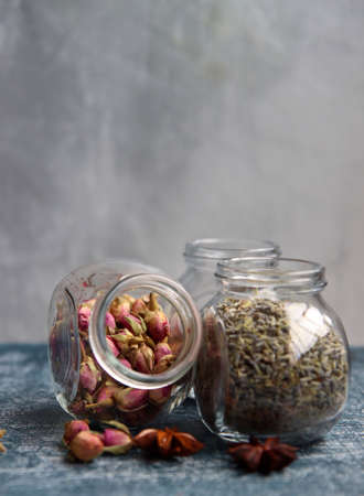 Spices for tea. Close up photo of small glass jars full with dry rose and lavender flowers.の写真素材