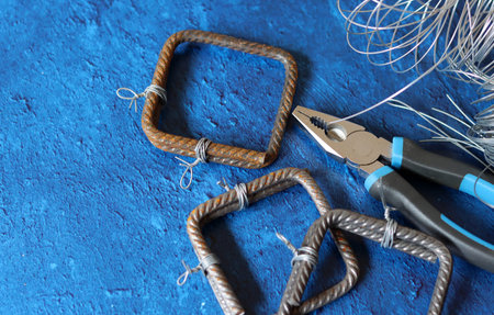 Pliers, wire and electric cable on color background, closeup
