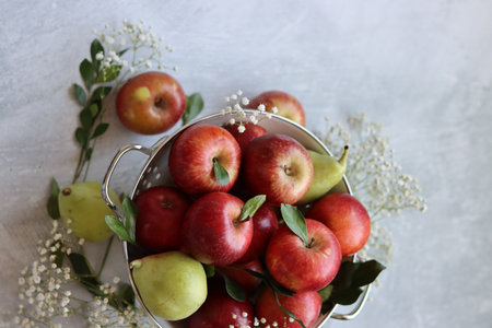 Fresh red apples in a metal bowl on a light background, top viewの写真素材