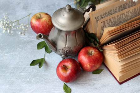 Composition with books, apples and vintage teapot on light backgroundの写真素材