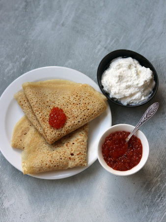 Shrove Tuesday celebration. Tiny Crepes on a plate. Festive food close up photo.の写真素材