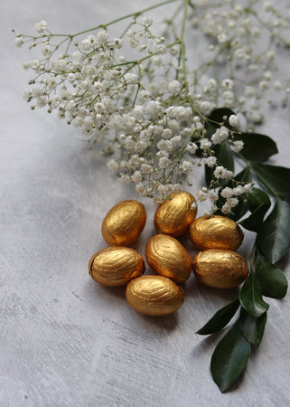 Foil wrapped Easter chocolate eggs. Easter celebration concept. Still life with sweets. Textured background with copy space. Easter greeting card.の写真素材