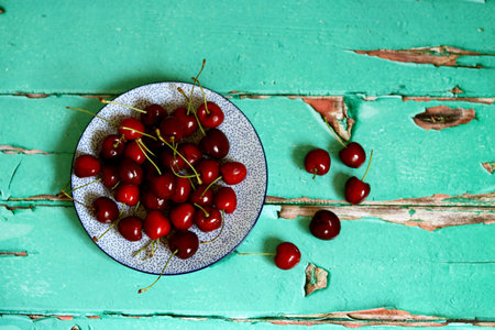 Cherries in a plate on a wooden background. Toned. Eating fresh concept.の写真素材