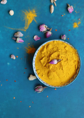 Turmeric powder in a bowl on a blue background, top viewの写真素材