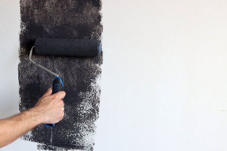Painter paints the wall with a roller, copy space for textの写真素材