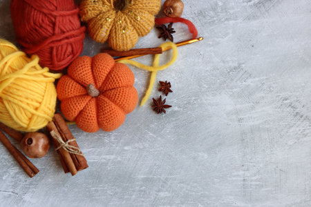 Handmade knitted pumpkins, cinnamon and anise on gray backgroundの写真素材