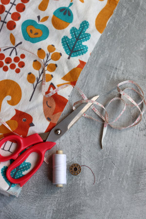 Sewing dress of soft flannel fabric, work in process. Sewing tools and accessories for needlework on...