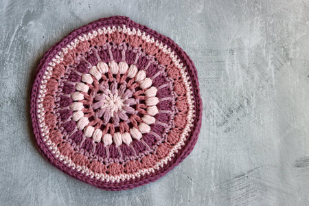 Handmade crocheted doily on grey background. Top viewの写真素材