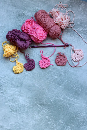 Granny squares crocheting in process. Colorful Afghan squares pattern close up photo. Grey...