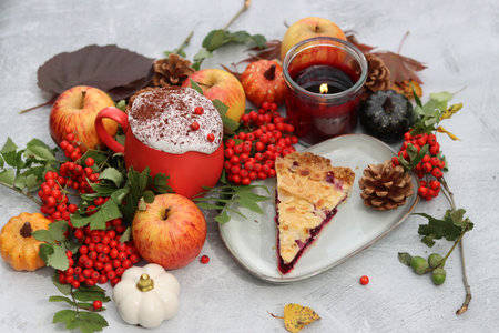 Autumn still life with a cup of coffee, pumpkins, apples and rowan berriesの写真素材