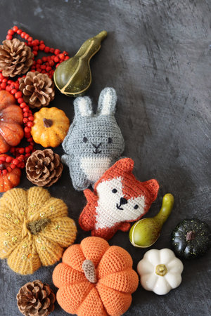 Handmade knitted woolen toy rabbit and pumpkin on dark backgroundの写真素材