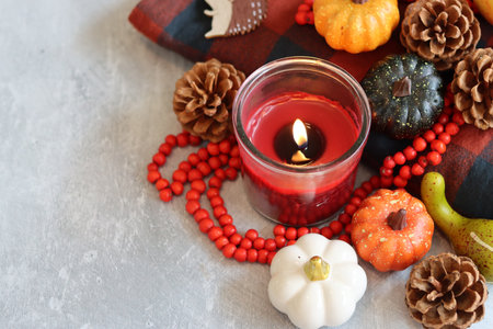 Pumpkin, red rosary and candle on a gray backgroundの写真素材