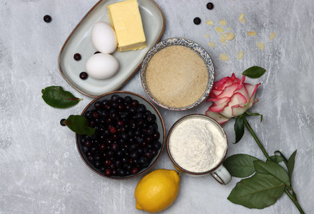 Blueberry pie ingredients on a table. Top view photo of freshly cropped berries, brown sugar, flour,...