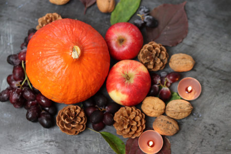 Autumn still life with pumpkins, apples and nuts on grey background with copy space. Healthy eating concept.の写真素材