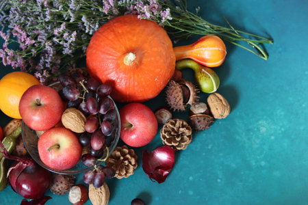 Autumn still life with pumpkins, apples, grapes, nuts and flowers