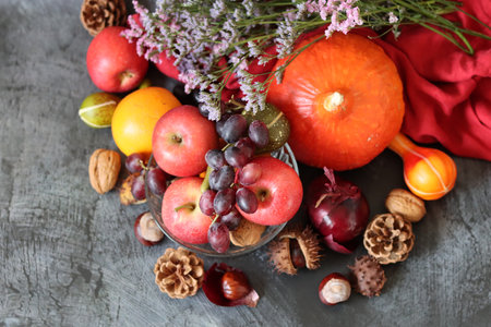 Autumn still life with pumpkins, apples, grapes, nuts and flowers with space for text. Eating fresh concept.の写真素材