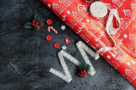 Christmas background with red gift wrapping paper, fir tree branches, candy canes and snowflakes on dark backgroundの写真素材