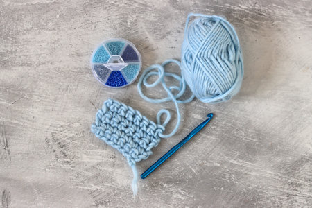 Crochet. Crochet hook, ball of blue woolen  a yarn on a blue background with copy space. Hobby and...