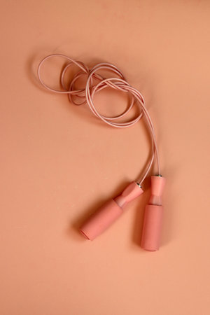Pink skipping rope on a pink background. Flat lay, top view.の写真素材