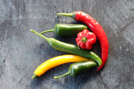 Hot chili peppers on a black background. Red, green and yellow peppers.の写真素材