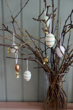 Easter eggs hanging on a branch in the rustic style.
