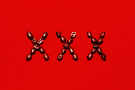 XXX symbol made of coffee beans on the red velvet background.の写真素材