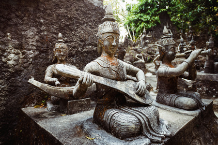 Row of old statues in secret buddhist garden. Concept of mysterious place for relaxation and meditation.の写真素材