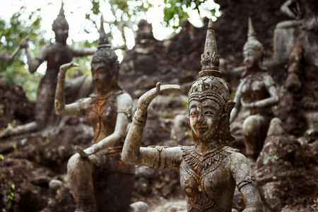 Row of old statues in secret buddhist garden. Concept of mysterious place for relaxation and meditation.の写真素材