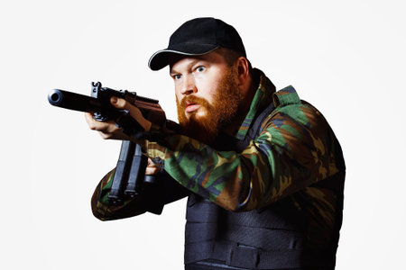 Terrorist in camouflage with red beard and cruel face is holding rifle isolated at white background.