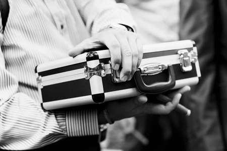 Closeup black and white image of man holding metal money business case.の写真素材