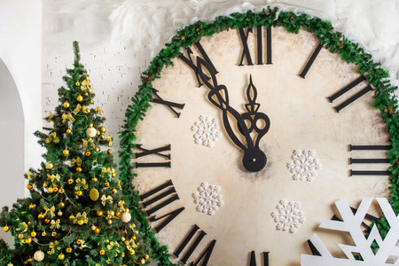 Closeup image of decorated Christmas tree at wall with big clock background.の写真素材