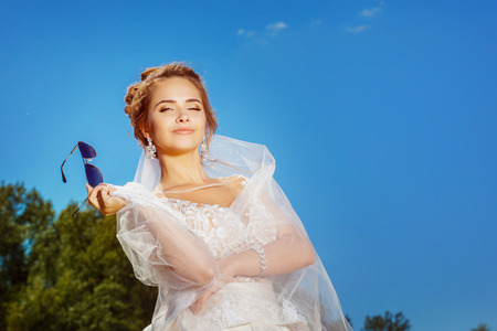 Closeup portrait of beautiful smiling bride at summer outdoors background.の写真素材