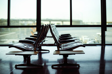 Row of leather chairs at international airport terminal background.の写真素材