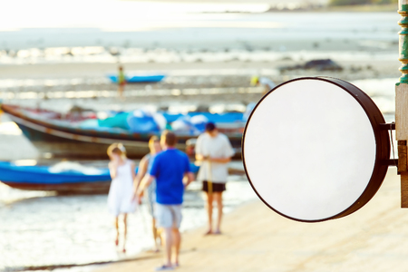 Mockup of beach restaurant round sign at asian seashore background.の写真素材