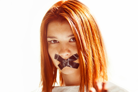 Closeup portrait of woman with taped mouth.の写真素材