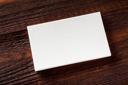 Closeup mockup of blank business card at brown wooden table background.の写真素材