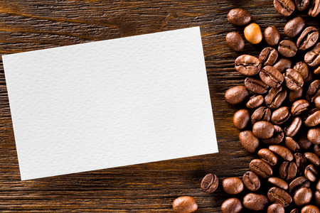 Mockup of blank business card at wooden table with coffee beans background.の写真素材