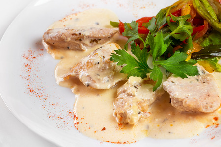 Plate of braised chicken meat with white sauce isolated.の写真素材