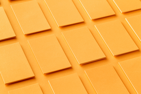 Mockup of vertical golden business cards stacks arranged in rows at textured paper background.の写真素材