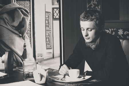 Closeup black and white portrait of man drinking coffee in vintage style cafe.の写真素材