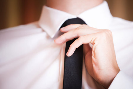 Closeup image of businessman correcting  black bow tie at mirror background.の写真素材