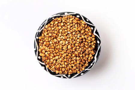 Marco image of raw buckwheat bowl isolated at white background. Traditional Russian porridge.の写真素材