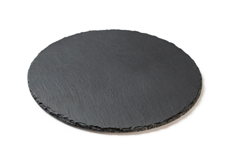 Round stone black plate for food serving isolated at white background.の写真素材
