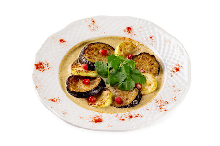 Plate of grilled eggplant and squash slices served with sauce isolated at white background.の写真素材