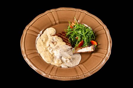 Roast veal with white mushrooms and truffle sauce served with fresh aragula salad siolated at black background.の写真素材