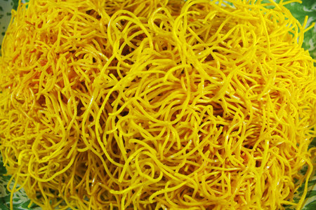 Top view of crispy yellow fried noodles texture with crunchy strands and rich golden color. Food...